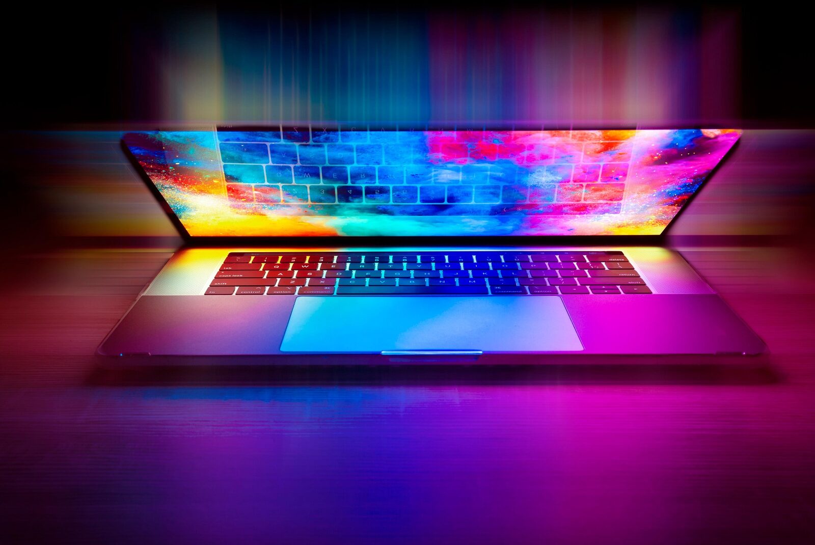 A laptop glowing with colourful light